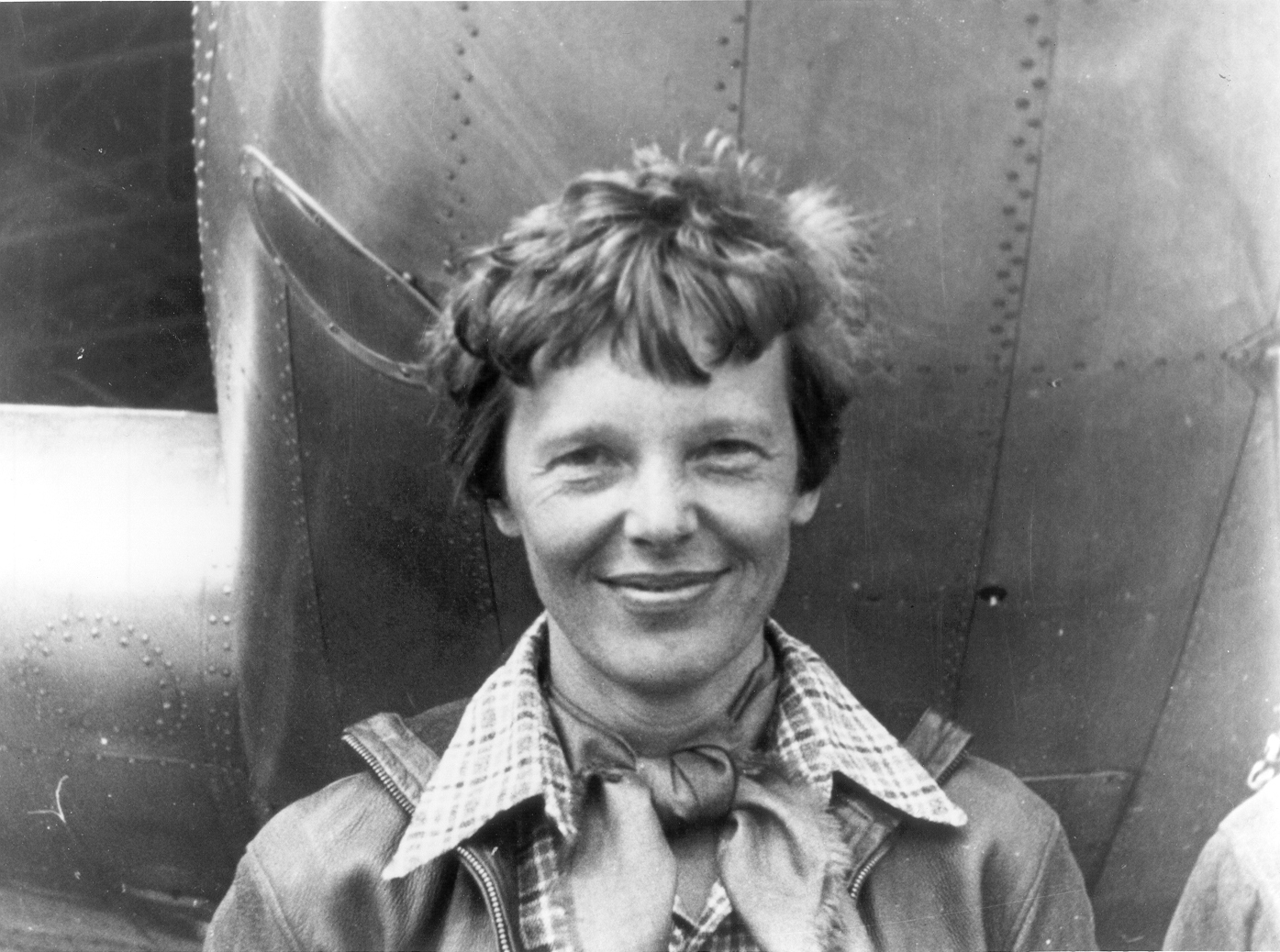 Amelia_Earhart_standing_under_nose_of_her_Lockheed_Model_10-E_Electra,_small